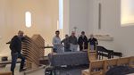 Helfer bringen Akustikfilz an Stühlen der Christuskirche an